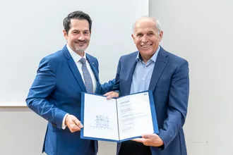 Präsident Thomas F. Hofmann bei der Überreichung der Ernennungsurkunde an Prof. Arthur Konnerth an der Mitgliederversammlung der TUM Senior Excellence Facutly im Dezember 2023. Bild: Andreas Heddergott / TUM 